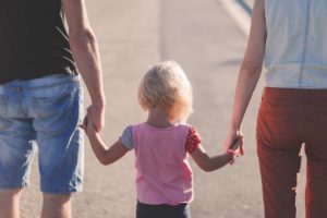 Family Lawyer Colorado- mother and father holding hands with child